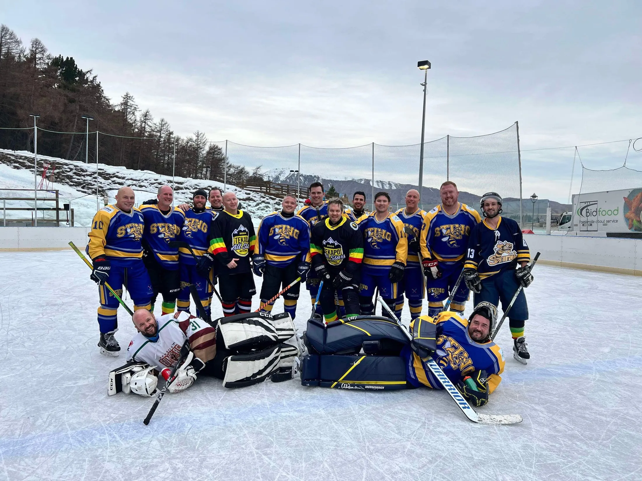 The Sunshine Coast Sting squad in blue and gold jerseys, posed together on an outdoor ice rink